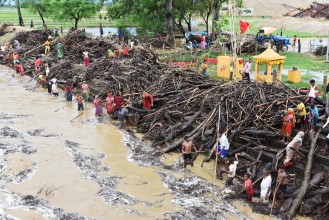 जोखिम मोलेर नदीबाट दाउरा झिक्दै स्थानीय